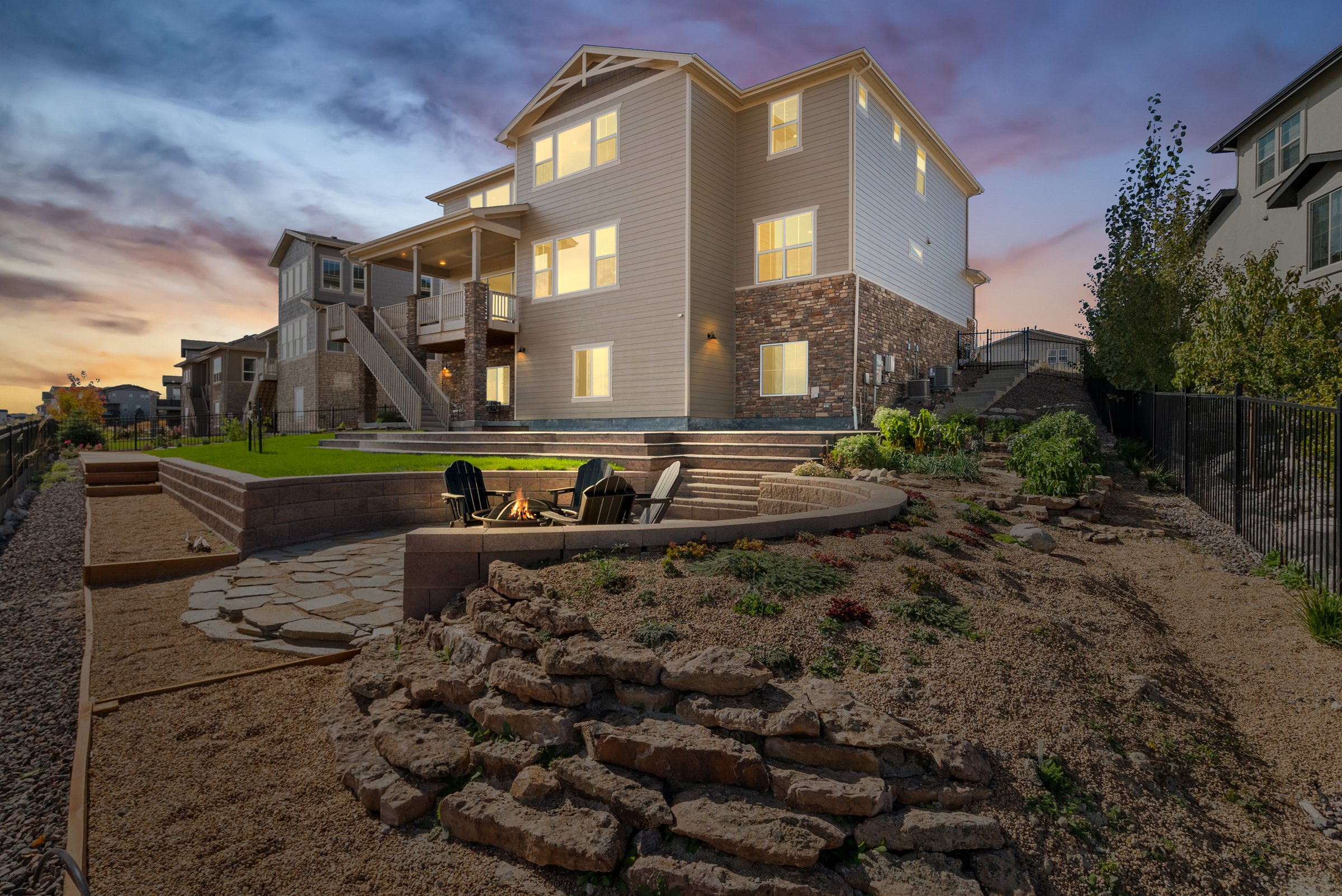 Twilight rear exterior, landscaped walkout, and fire-pit seating.