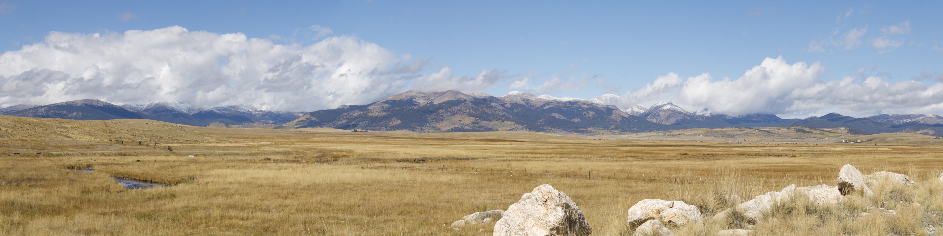 Snow-dusted Rocky Mountains under a wide Colorado sky.