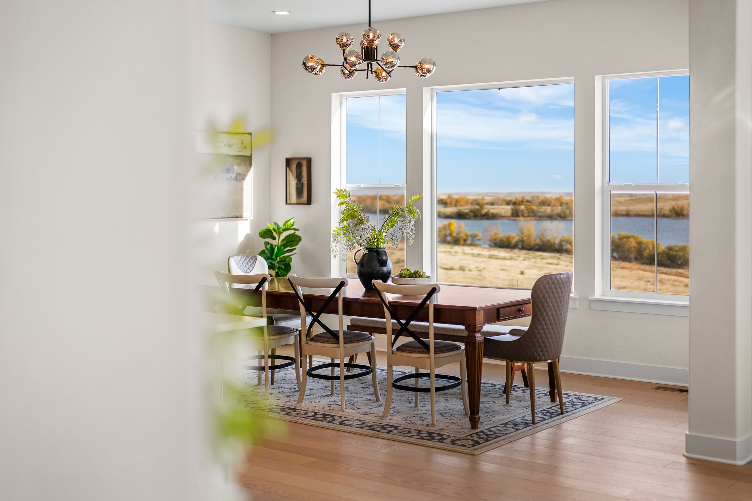 Dining area beside large windows with reservoir and prairie views.
