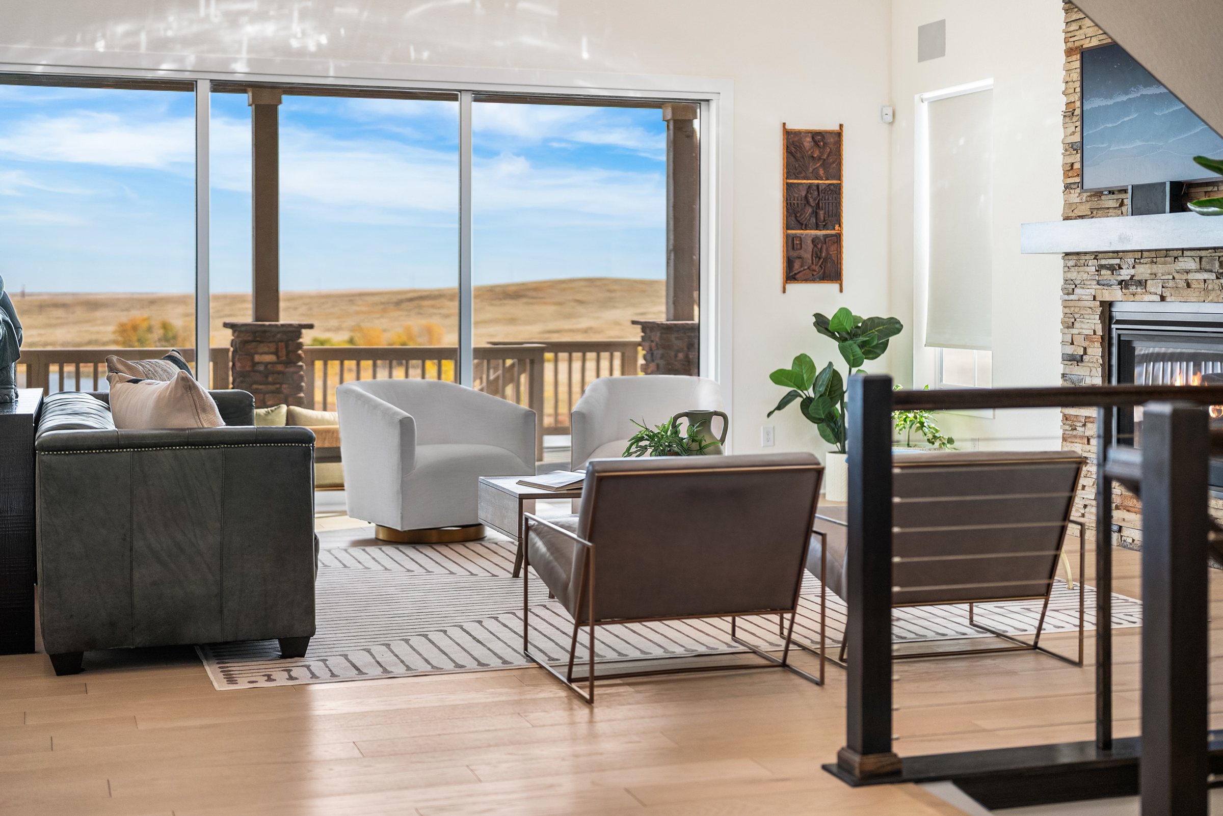 Great room seating looking through sliding glass to the covered deck and open space.