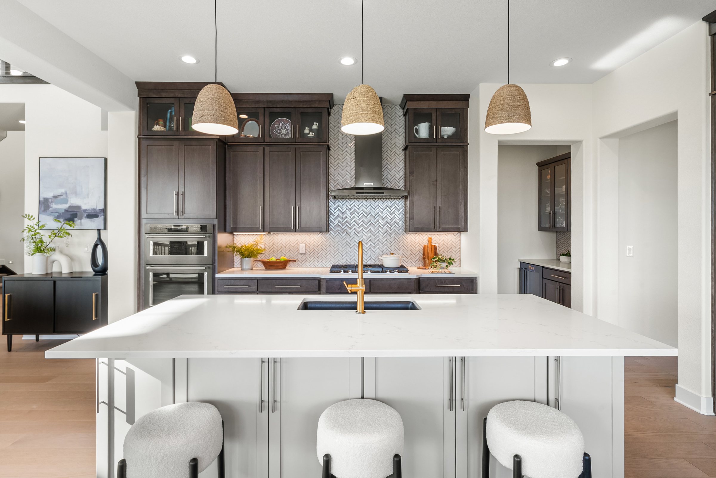 Kitchen island, pendant lighting, and dark cabinetry.