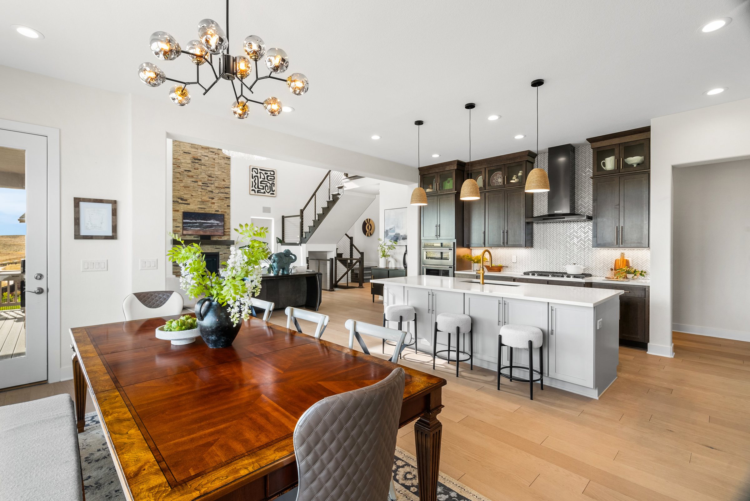 Open kitchen and dining area with island and chandelier.