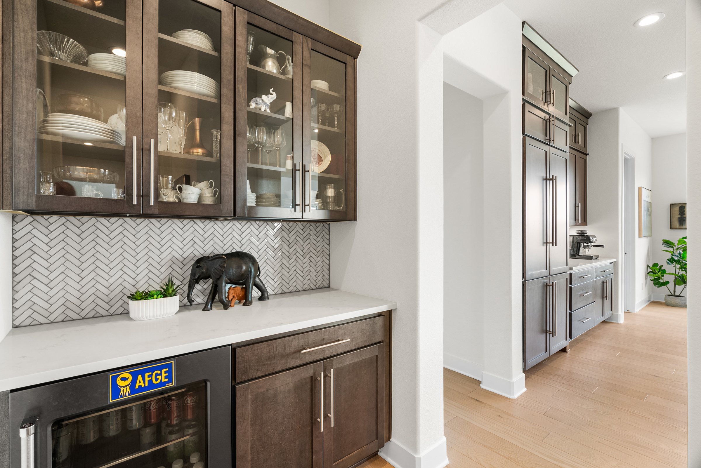Butler pantry with glass-front cabinetry and beverage refrigerator.