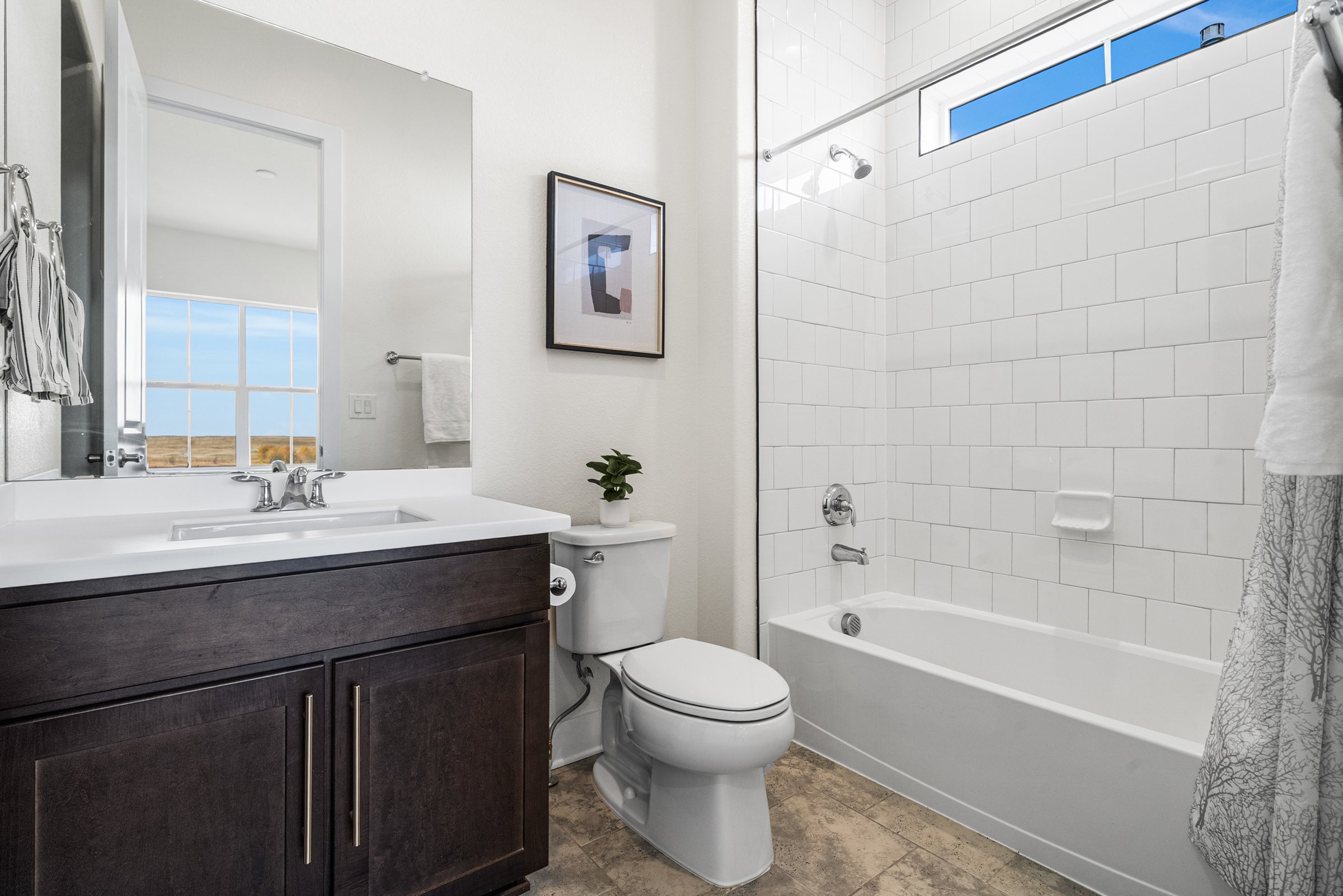 Secondary bath with tub-shower and vanity.