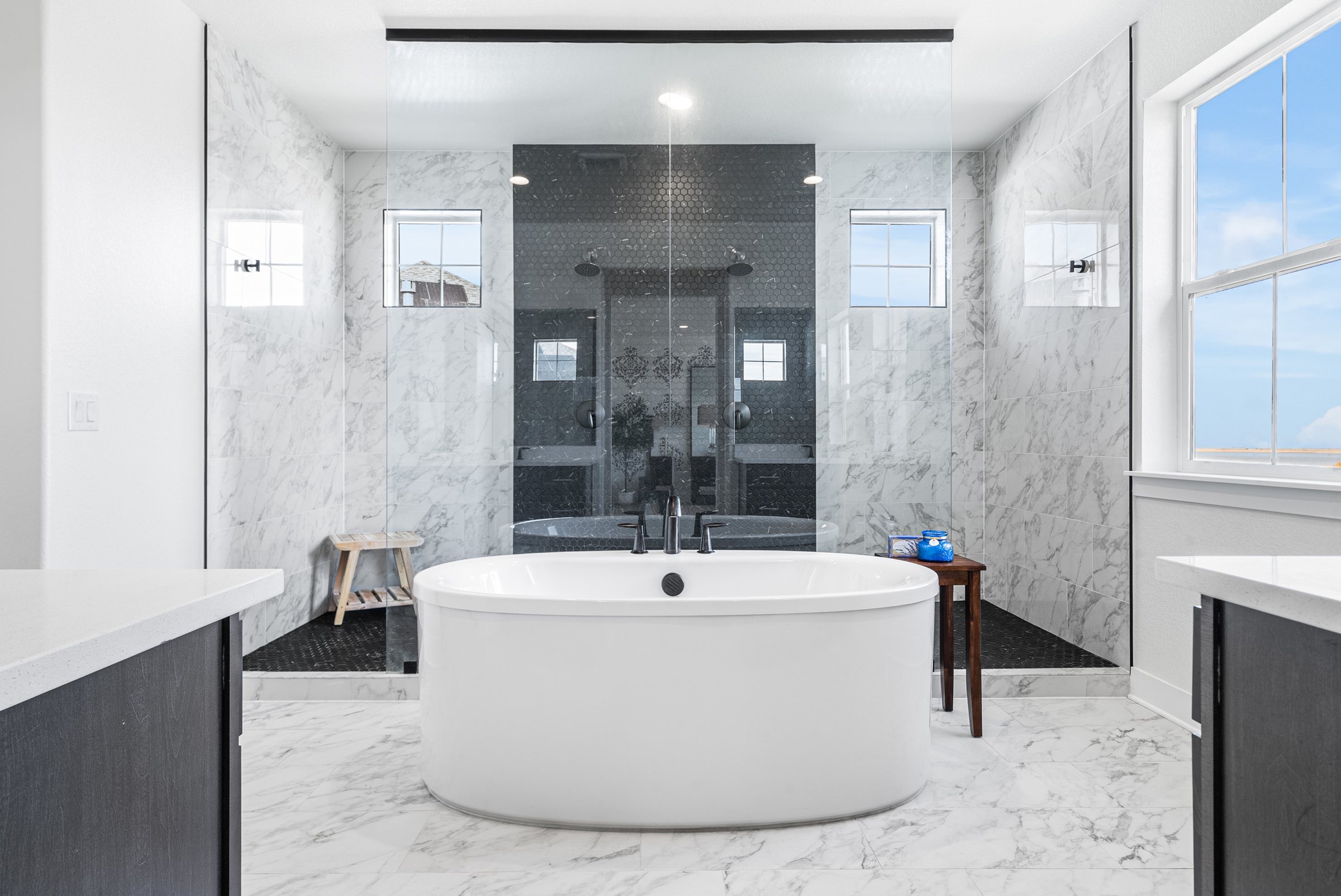 Primary bath with freestanding tub and glass shower.