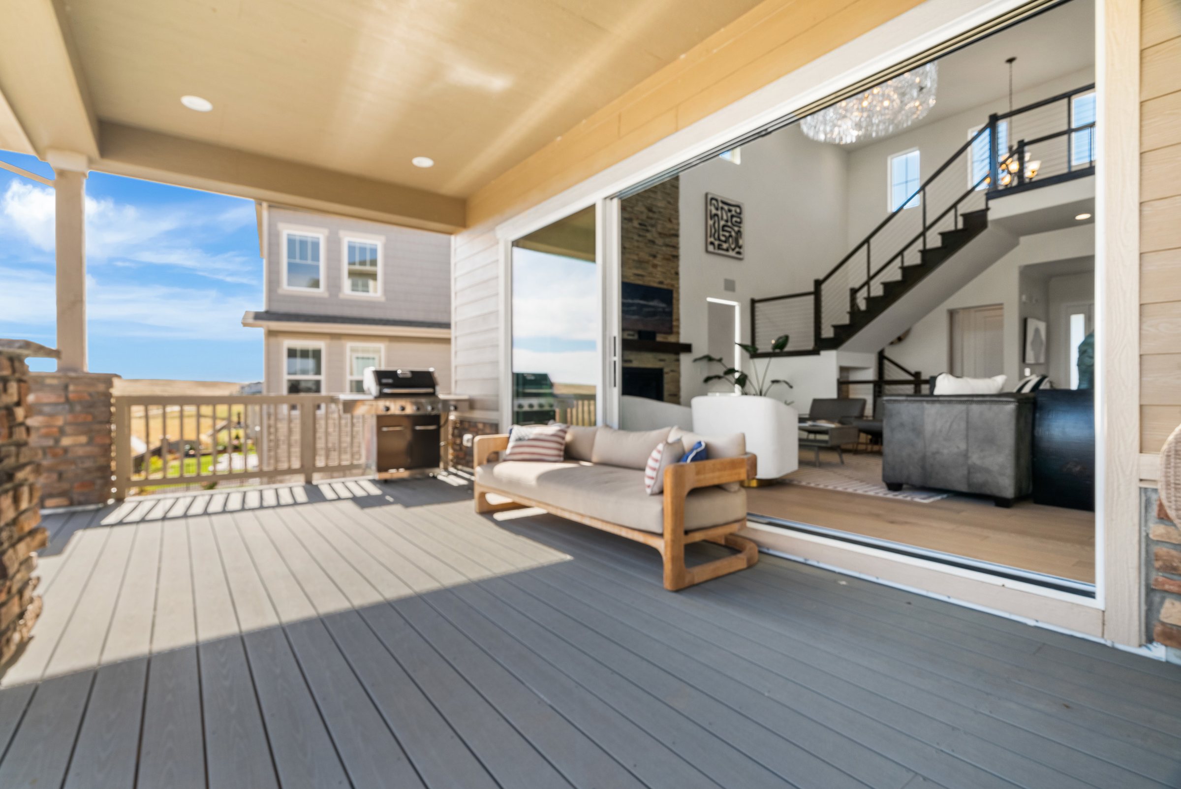 Covered deck connected to the great room through wide sliding glass.